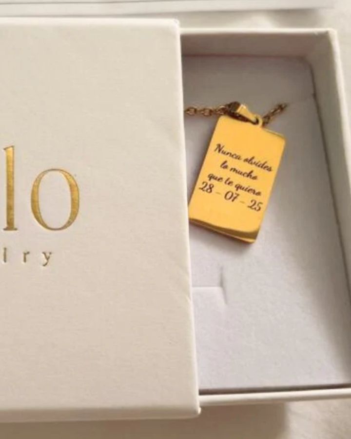 Colar dourado Ahlo com chapa retangular gravada na embalagem